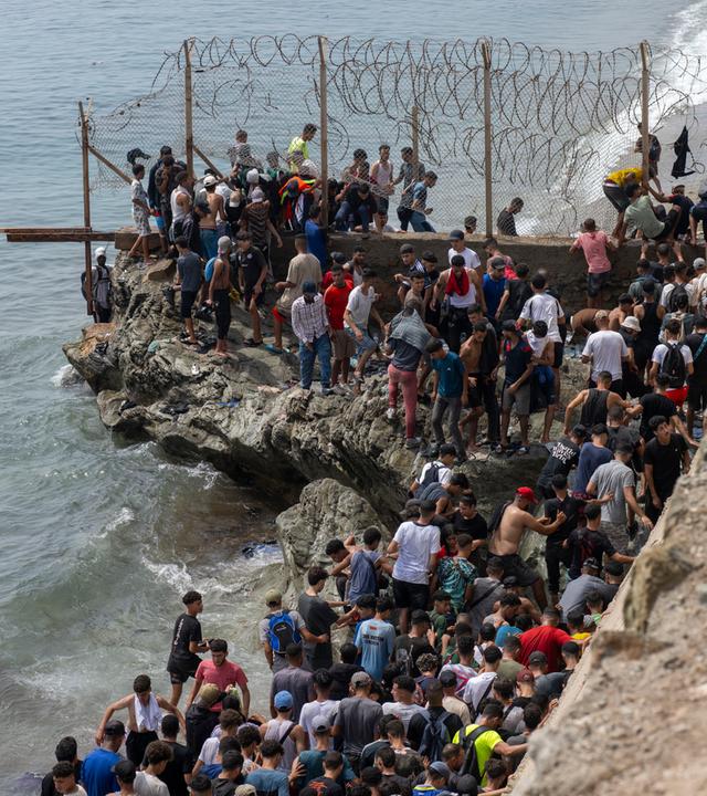 Junge Männer, die aus Spanien zurückgekehrt sind, versammeln sich am Grenzübergang Bab Sebta nahe Fnideq in Marokko.