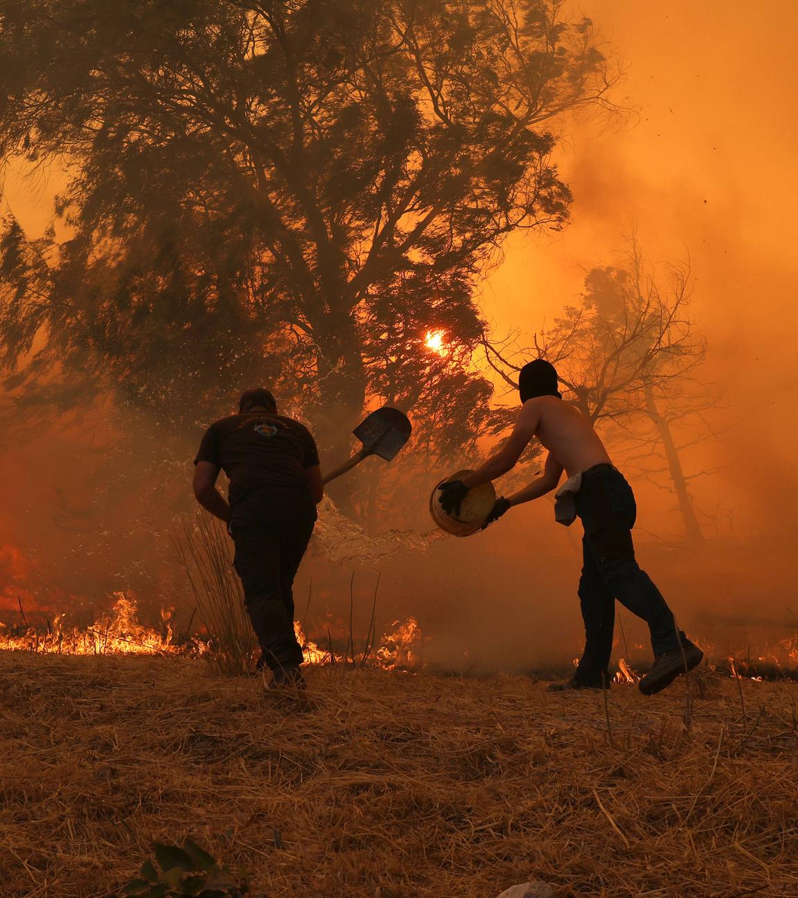 Rauch und Flammen steigen auf, während Feuerwehrteams einen Waldbrand nahe Athen bekämpfen