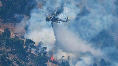 Ein Löschhubschrauber wirft Wasser über einen Waldbrand auf dem Berg Kithairon in der Nähe von Porto Germeno nordwestlich von Athen ab.