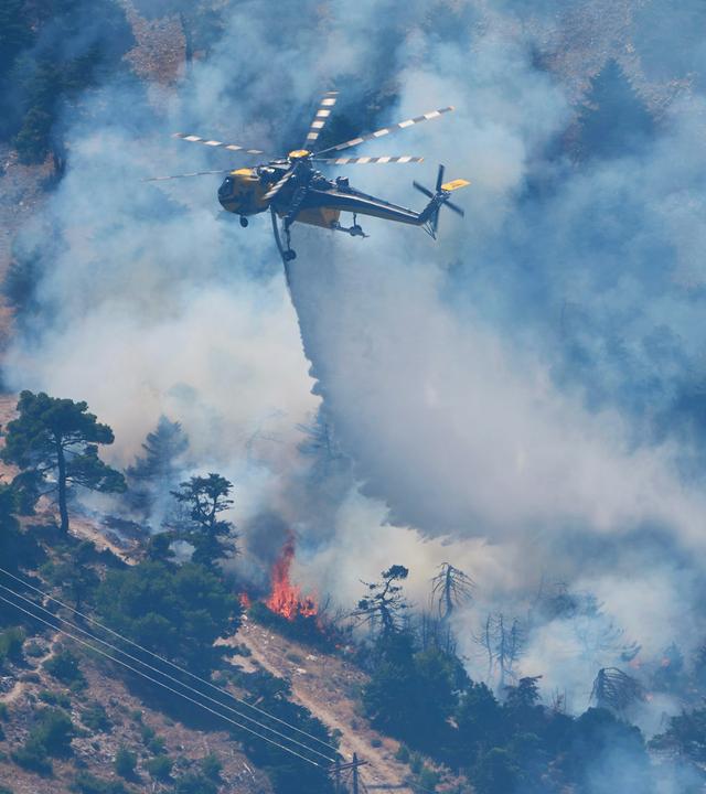 Ein Löschhubschrauber wirft Wasser über einen Waldbrand auf dem Berg Kithairon in der Nähe von Porto Germeno nordwestlich von Athen ab.