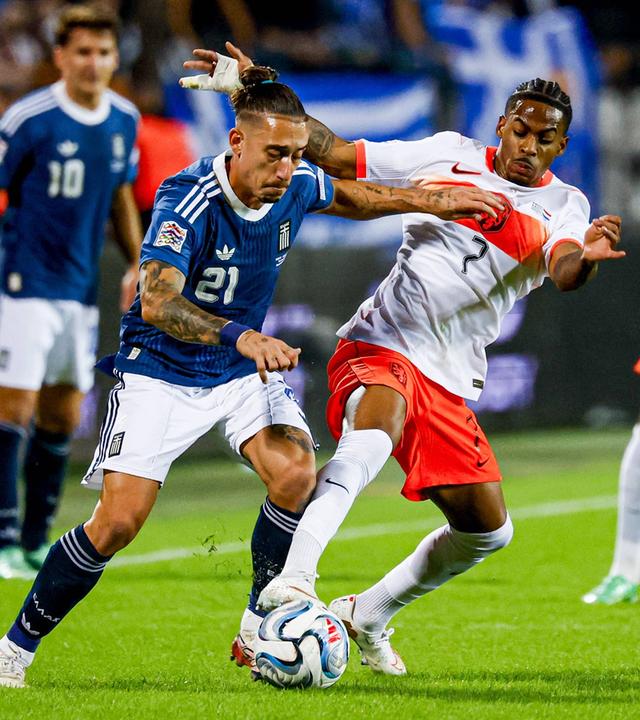 Kostas Tsimikas und Crysencio Summerville kämpfen im Nations League Spiel zwischen Griechenland und den Niederlanden um den Ball.