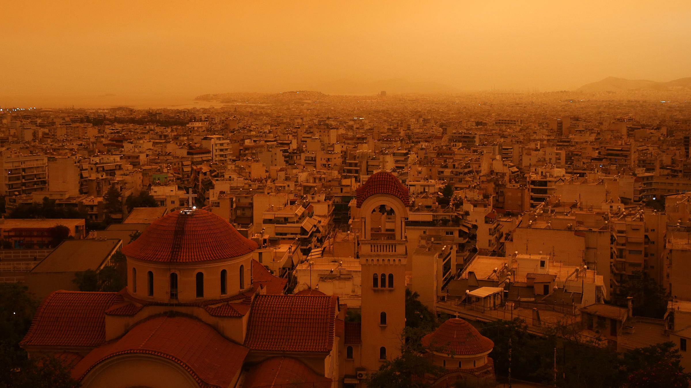 In Athen hat aus Afrika kommender Wüstenstaub den Himmel orange gefärbt