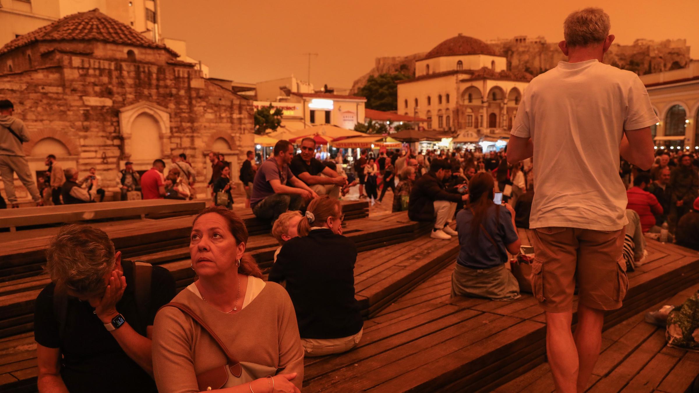 Menschen spazieren, während afrikanischer Staub den Himmel über Athen bedeckt