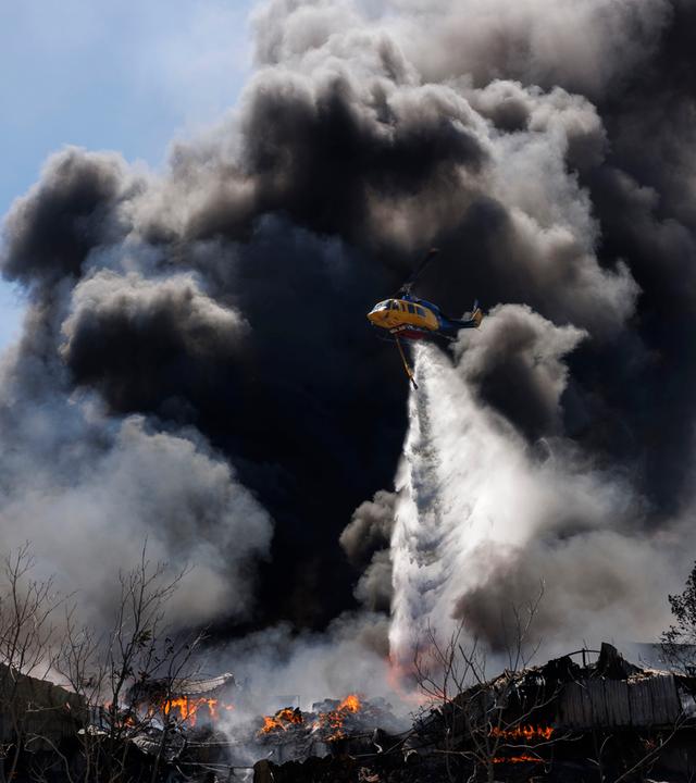 Ein Löschhubschrauber wirft Wasser auf einen Brand in der Vorstadtgemeinde Oreokastro in der Nähe von Thessaloniki, Griechenland.