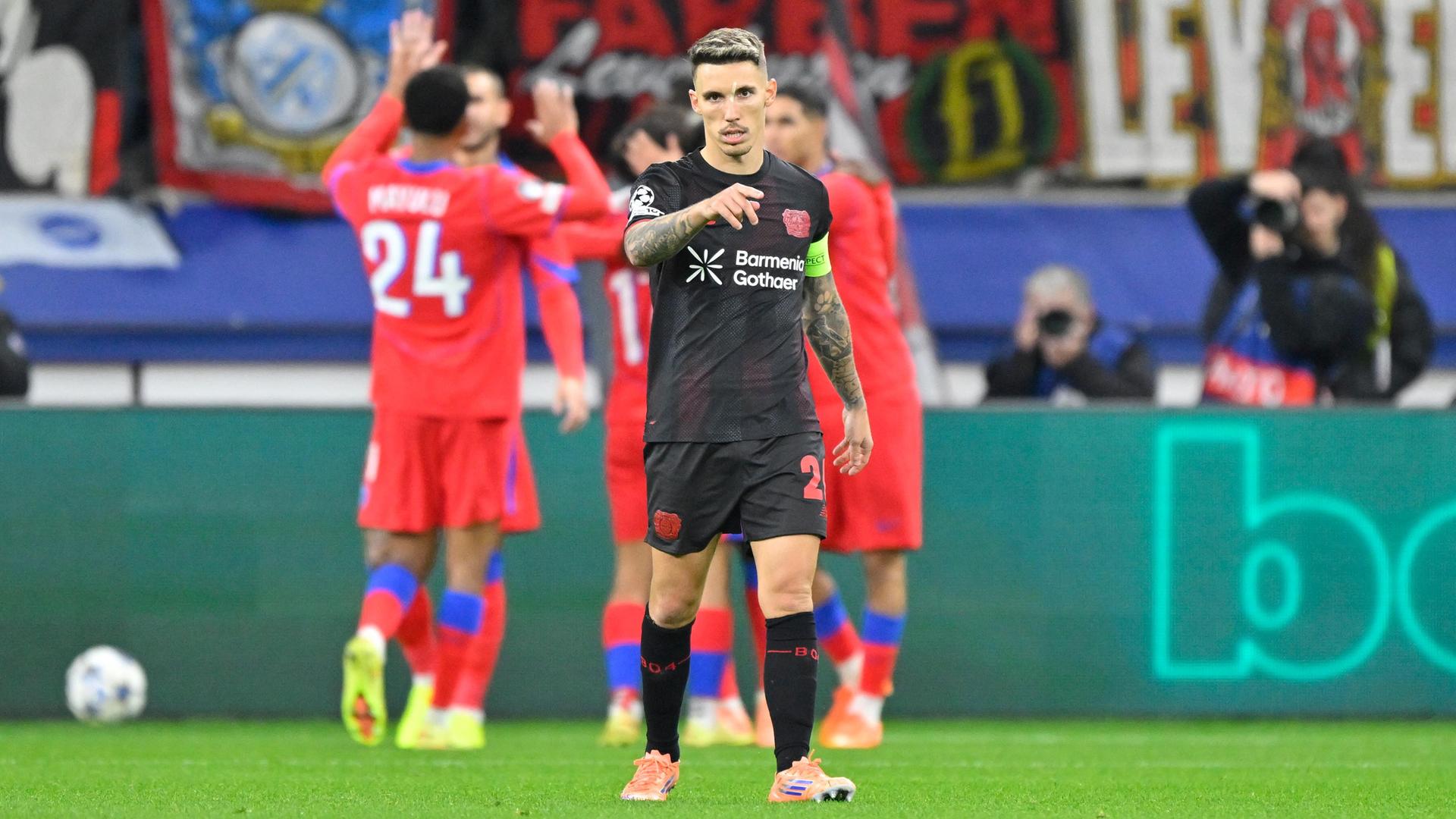 Alejandro Grimaldo vor feiernden PSG-Spielern.