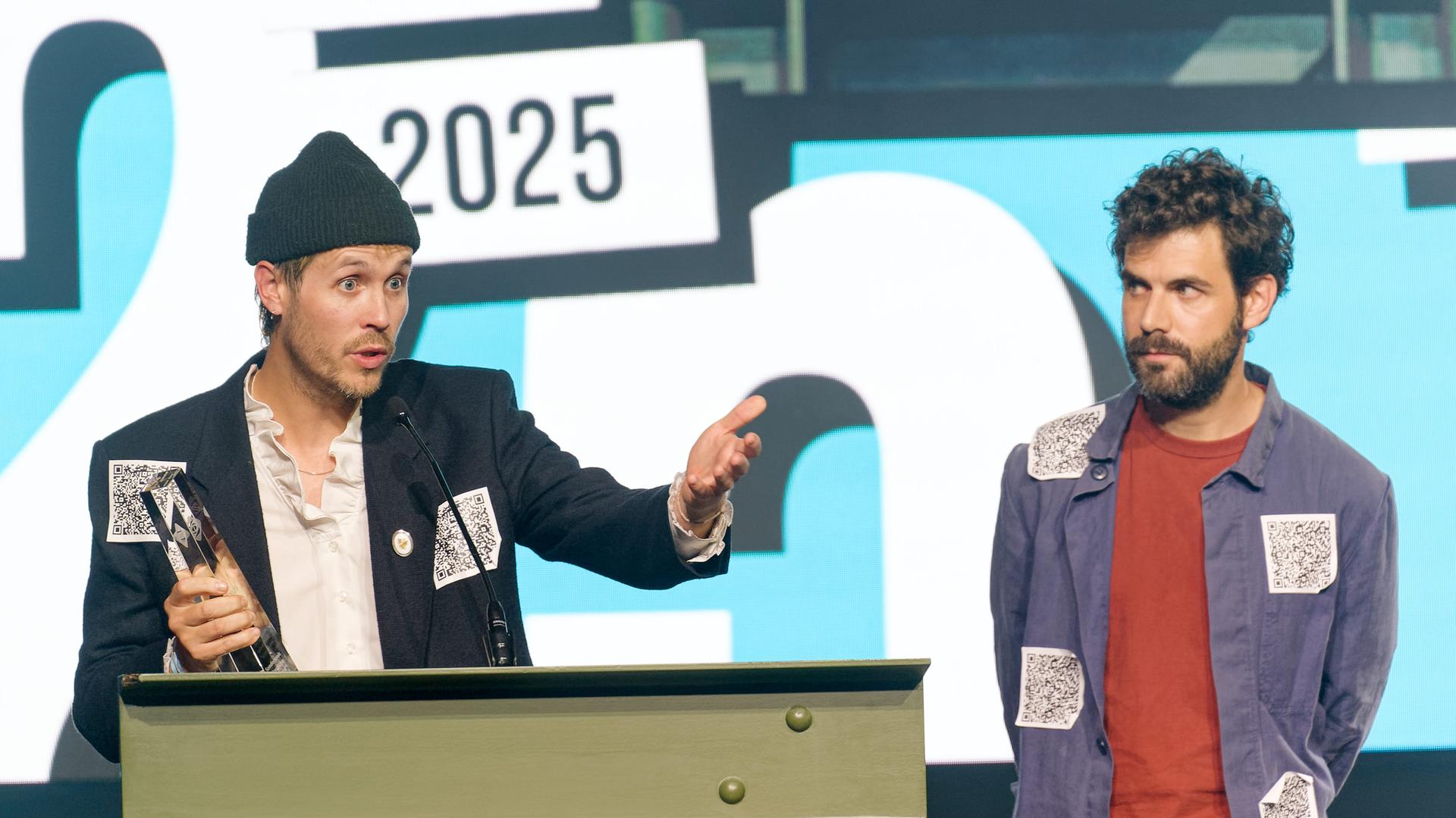 Hans Block (l), Moritz Riesewieck (r) lassen bei Verleihung der Grimme-Online-Awards ihren Preis in der Kategorie 'Sonderpreis Künstliche Intelligenz' auf der Bühne stehen, um gegen Aberkennung Bert-Donnepp-Preis von der Aktivistin Judith Scheytt zu protestieren.