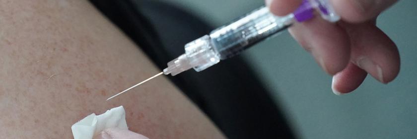 Eine Ärztin impft eine Person mit einem Impfstoff gegen Grippe