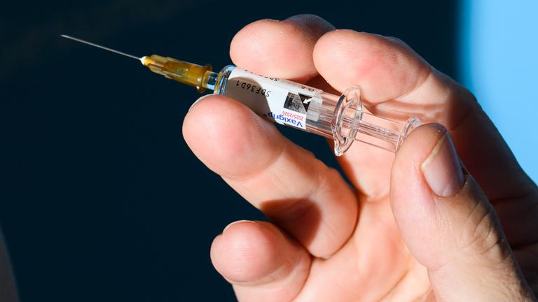 Ein Arzt hält bei einem Pressetermin zur Grippeschutzimpfung im niedersächsischen Gesundheitsministerium eine Spritze mit dem Grippeimpfstoff.