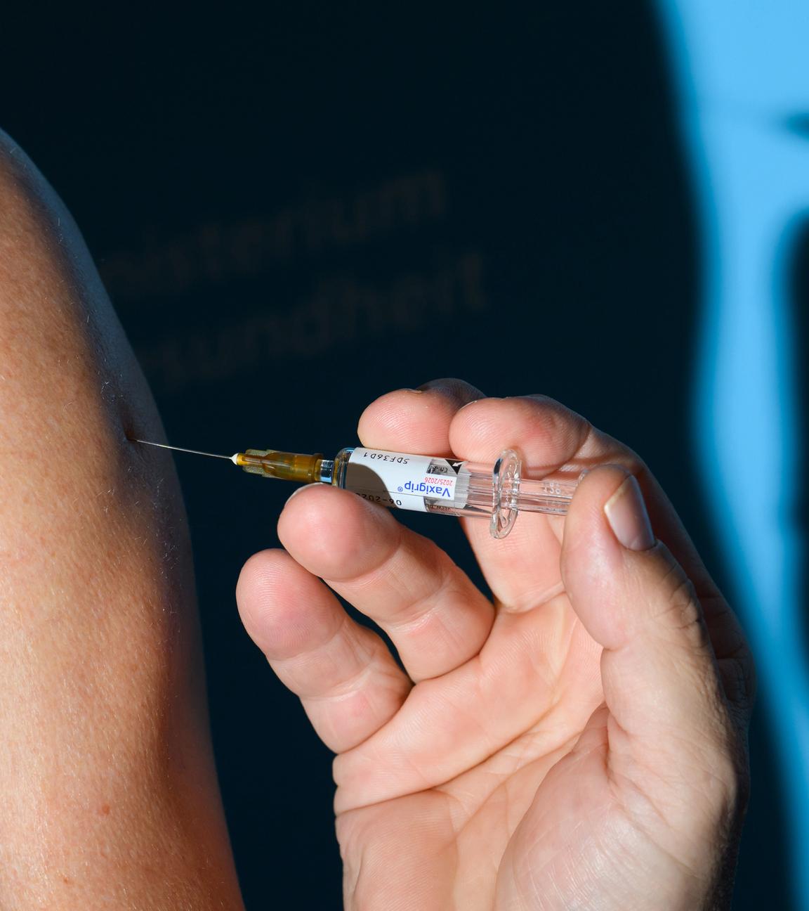 Ein Arzt impft einen Mann bei einem Pressetermin zur Grippeschutzimpfung im niedersächsischen Gesundheitsministerium mit dem Grippeimpfstoff Vaxigrip