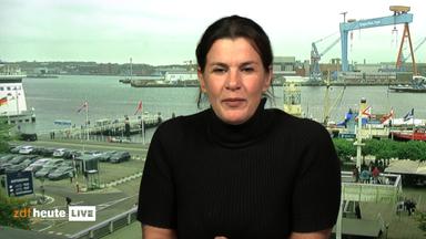 ZDF-Skandinavien-Reporterin Sohad Khaldi in einem Studio. Der Hintergrund ist eine Aufnahme eines Hafen.