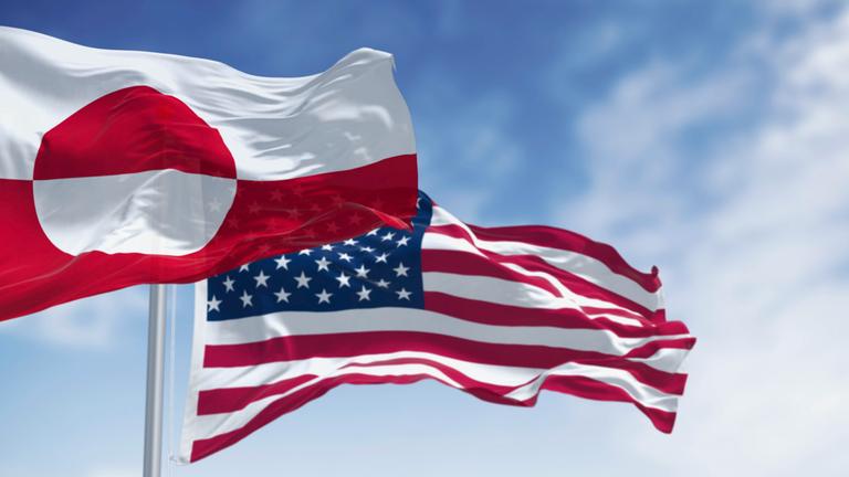 Die Flaggen von Grönland und den USA wehen an einem klaren Tag im Wind - Bildmontage