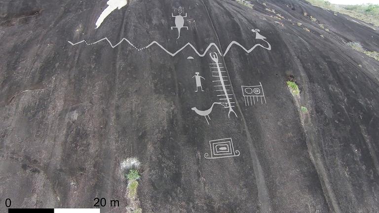 An einem Felsen sind Petroglyphen und ihre entsprechende Größe im Verhältnis zum Maßstab