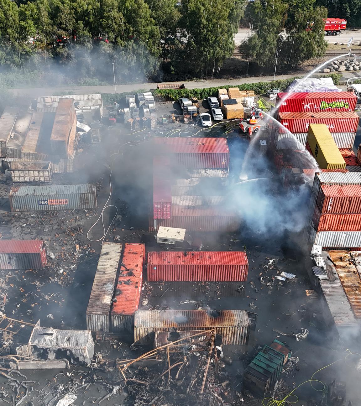 26.08.2025, Hamburg: Einsatzkräfte der Feuerwehr löschen einen Brand in einem Industriegebiet im Hamburger Hafen, in dem am Vortag ein Großbrand ausgebrochen war.