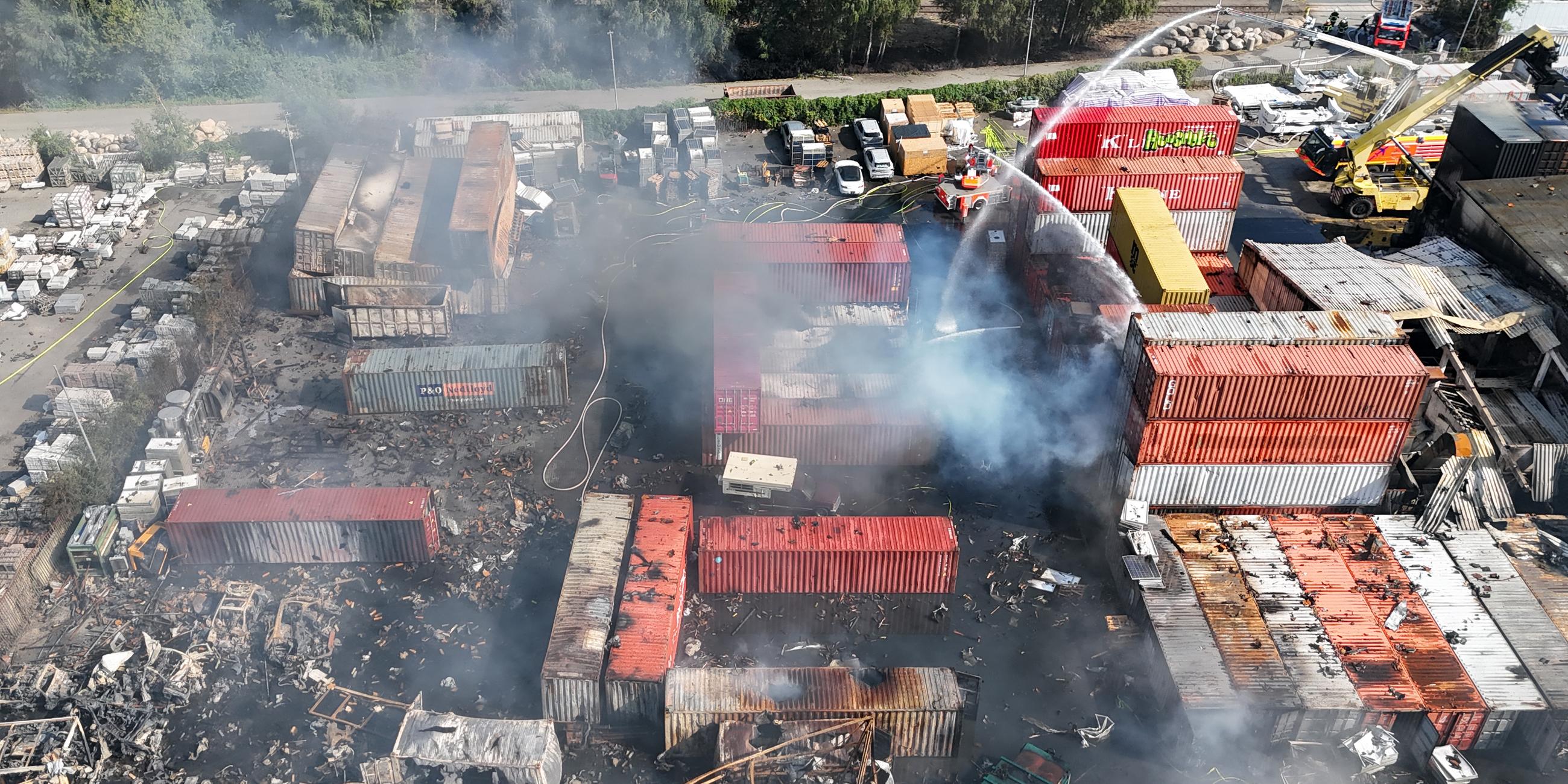 26.08.2025, Hamburg: Einsatzkräfte der Feuerwehr löschen einen Brand in einem Industriegebiet im Hamburger Hafen, in dem am Vortag ein Großbrand ausgebrochen war.