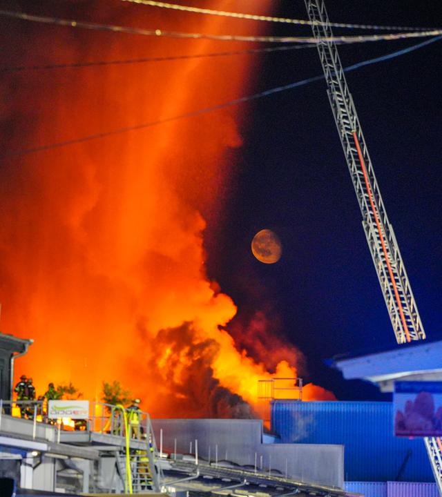Einsatzkräfte der Feuerwehr bekämpfen einen Brand in einem Gewerbegebiet in Stuttgart.