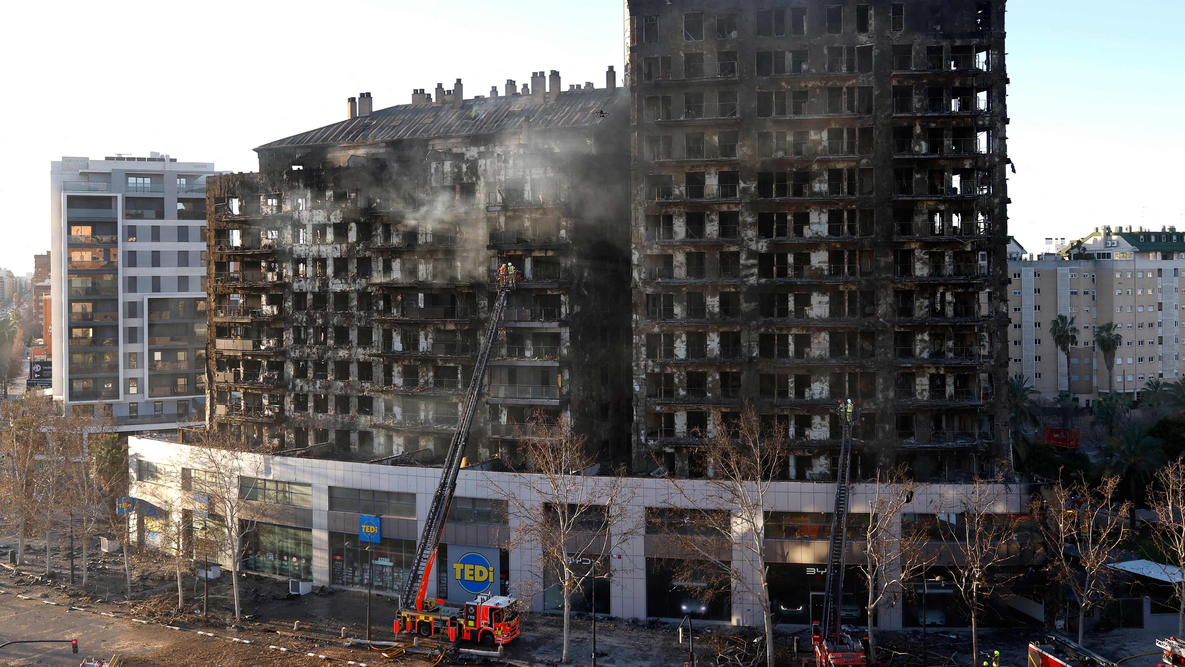 Feuerwehrleute inspizieren am 23.02.2024 in Valencia die Folgen eines Großbrandes, der gestern in einem mehrstöckigen Wohnblock wütete und mindestens vier Menschen tötete.