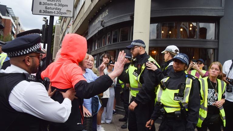 Großbritannien, London: Die Polizei entfernt einen Migrationsgegner vor dem Thistle Hotel in der Nähe des Barbican.