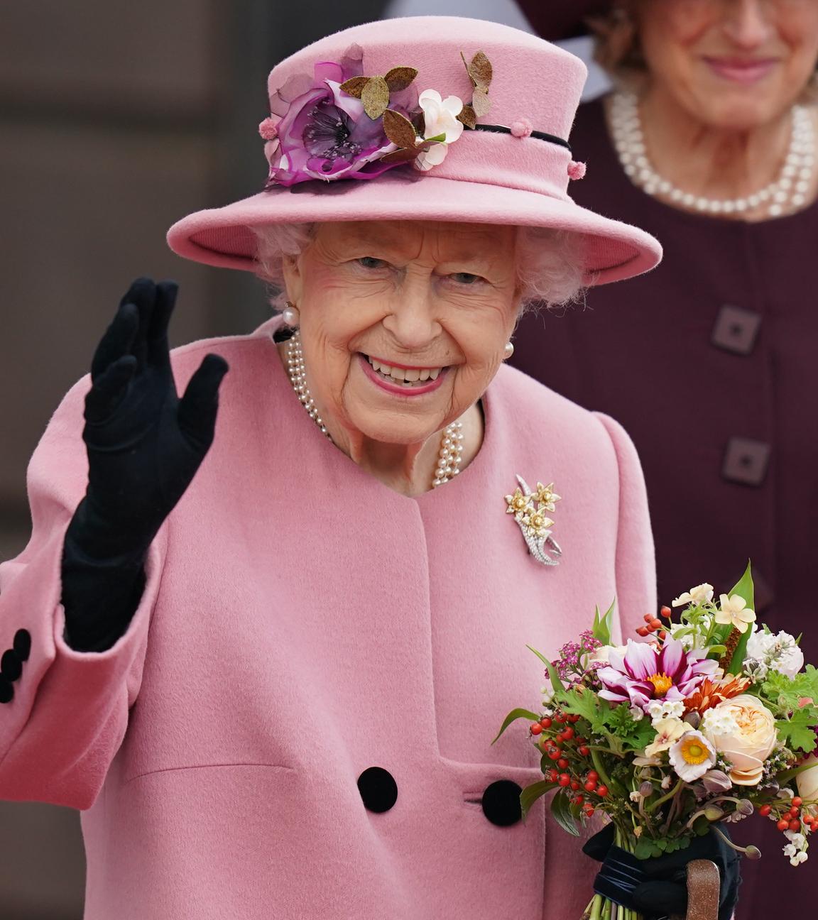 Die britische Königin Elizabeth II. hält einen Blumenstrauß in der Hand und winkt, nachdem sie nach der Eröffnungszeremonie des walisischen Parlaments das Parlamentsgebäude verlässt. (zu dpa «Palast: Queen verbrachte Nacht auf Donnerstag im Krankenhaus»)