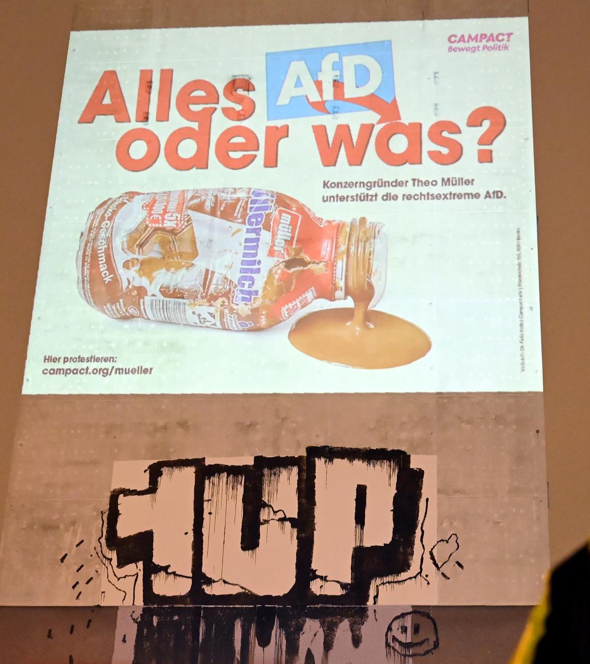 Berlin: Ein Polizist telefoniert vor einer Projektion mit dem Slogan Alles AfD, oder was am Alexanderplatz.