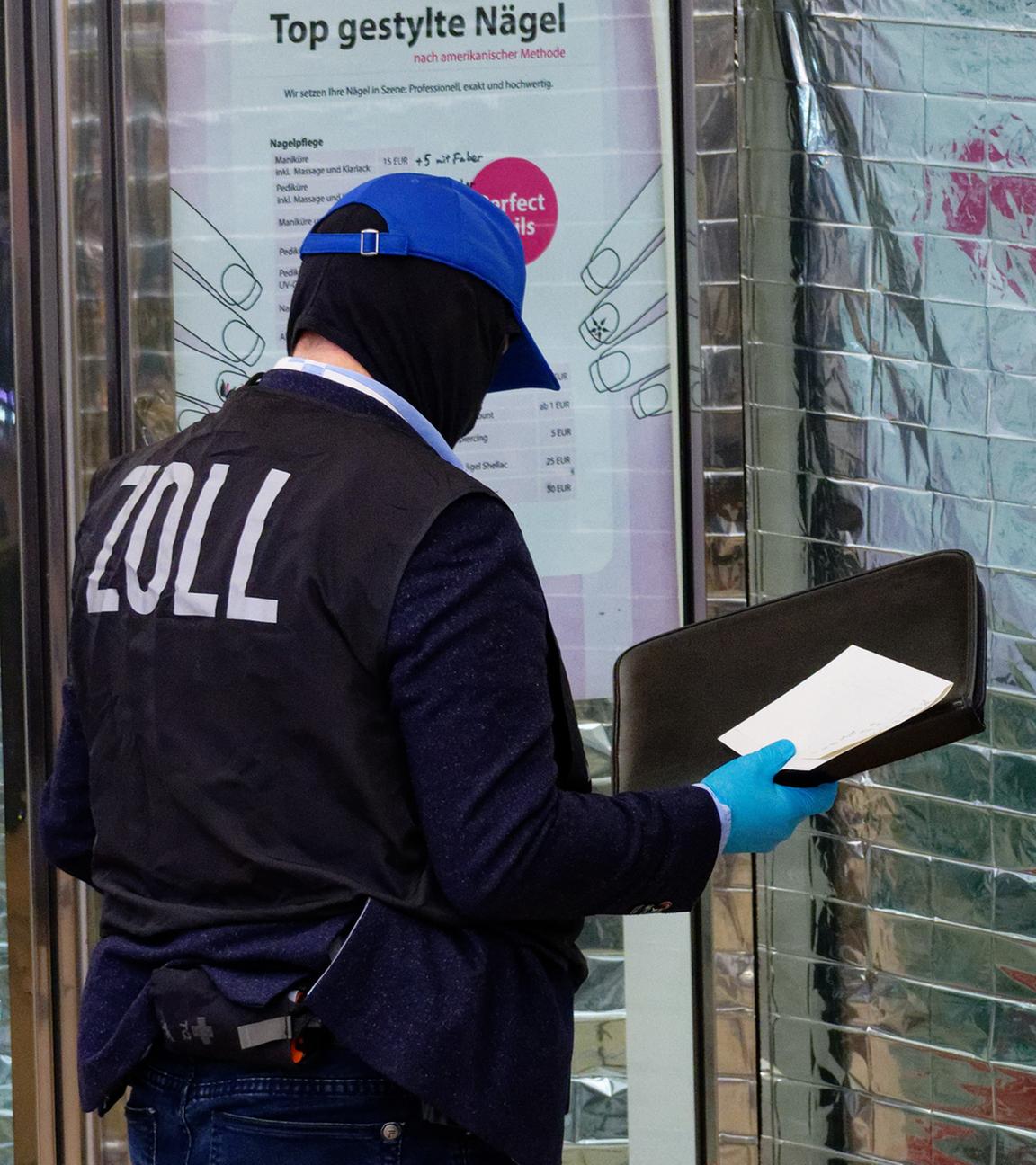 Zollbeamte stehen vor einem Nagelstudio in der Neumarktgalerie in der Innenstadt.