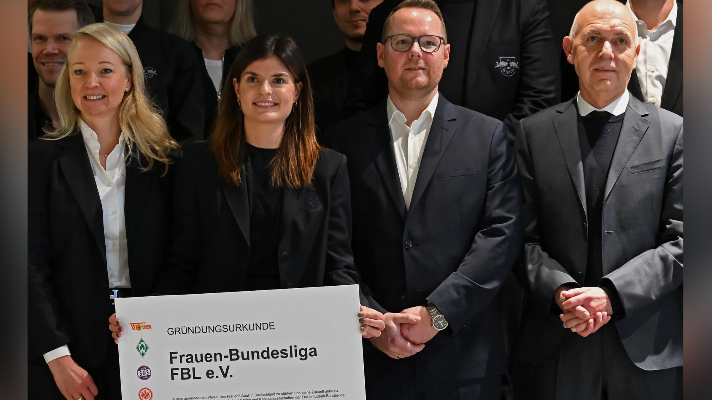 Die erste FBL-Präsidentin Katharina Kiel (Mitte mit Gründungsurkunde) steht neben den Vize Veronica Saß (l) und Florian Zeutschler sowie DFB-Präsident Bernd Neuendorf (rechts). 