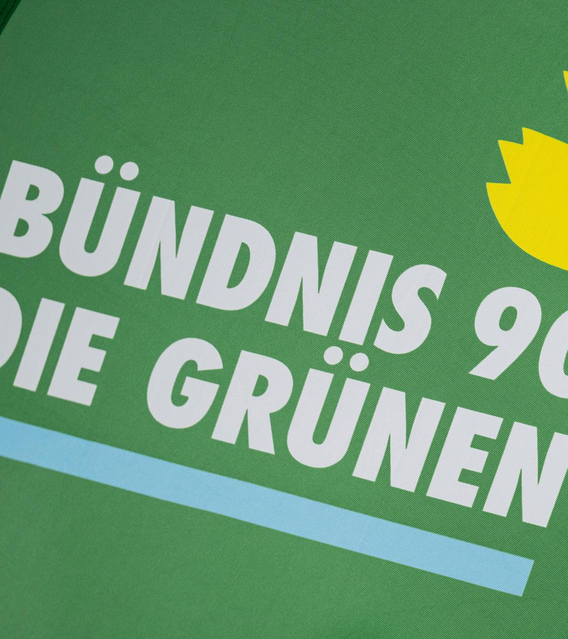 Das Logo der Partei Bündnis 90/Die Grünen steht auf einer Fahne.