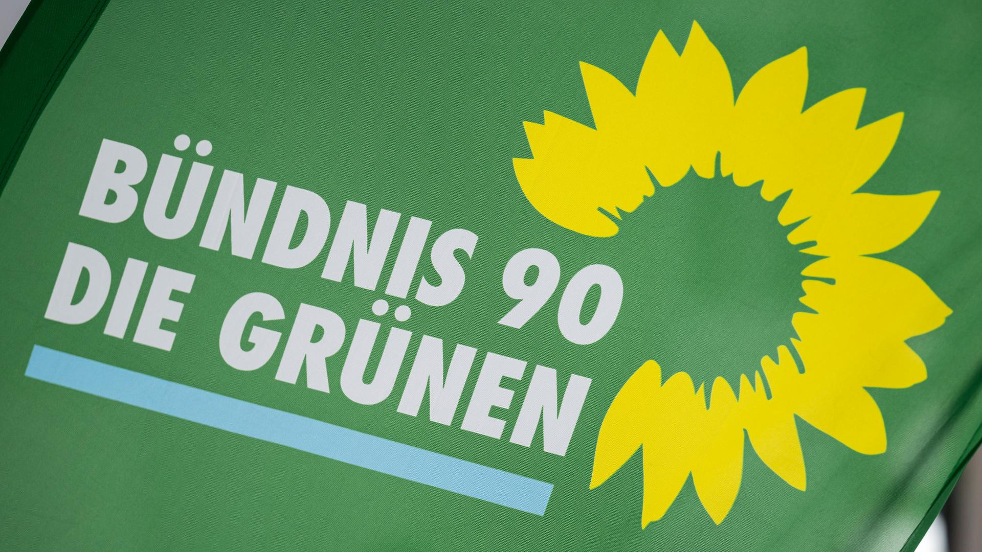 Das Logo der Partei Bündnis 90/Die Grünen steht auf einer Fahne.