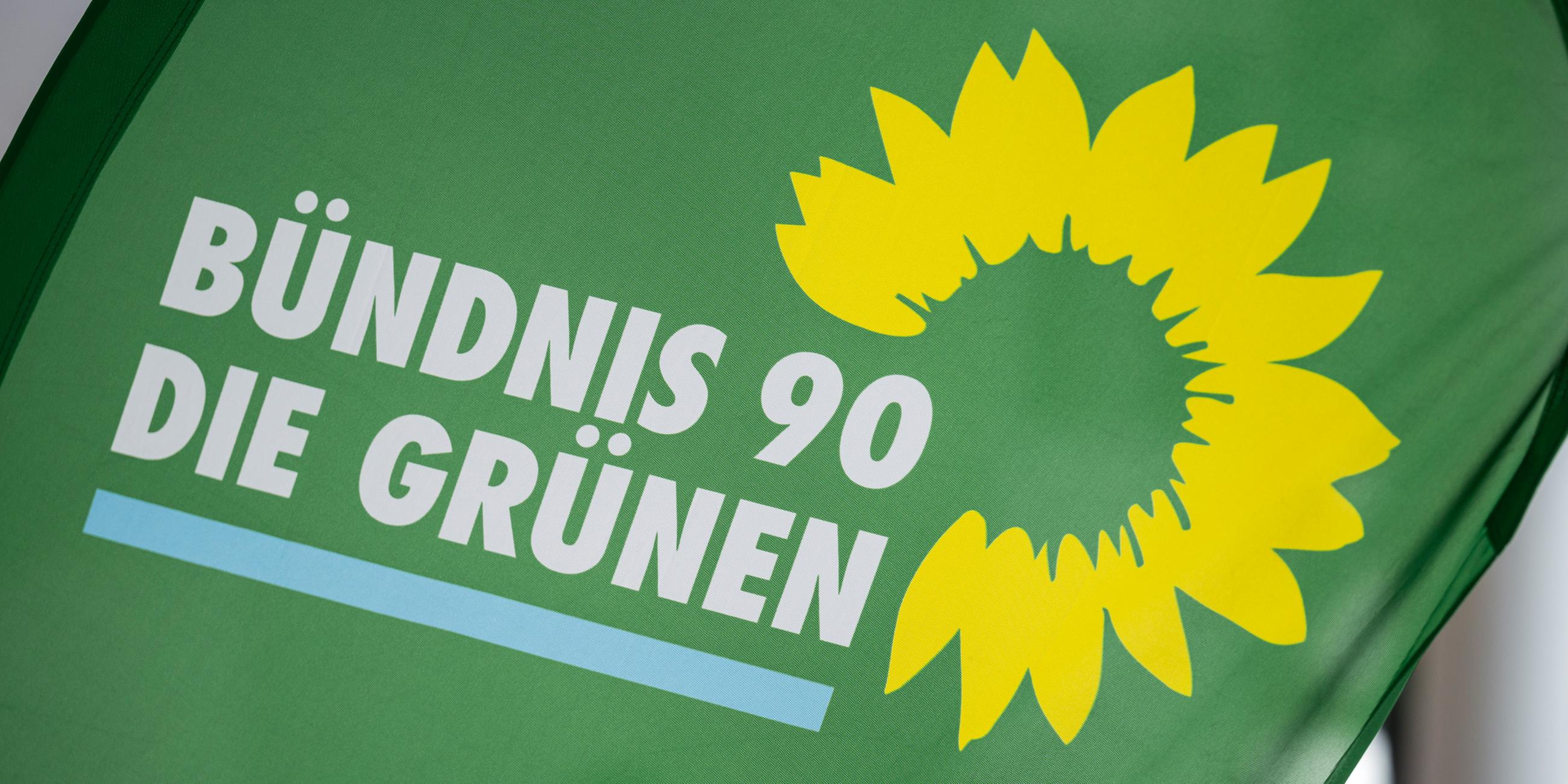 Das Logo der Partei Bündnis 90/Die Grünen steht auf einer Fahne.