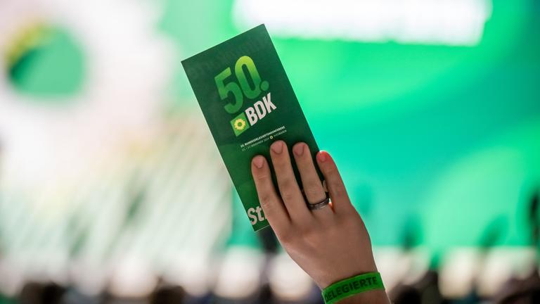 Delegierte halten bei der Antragsberatung bei der Bundesdelegiertenkonferenz der Grünen die Stimmkarten hoch.