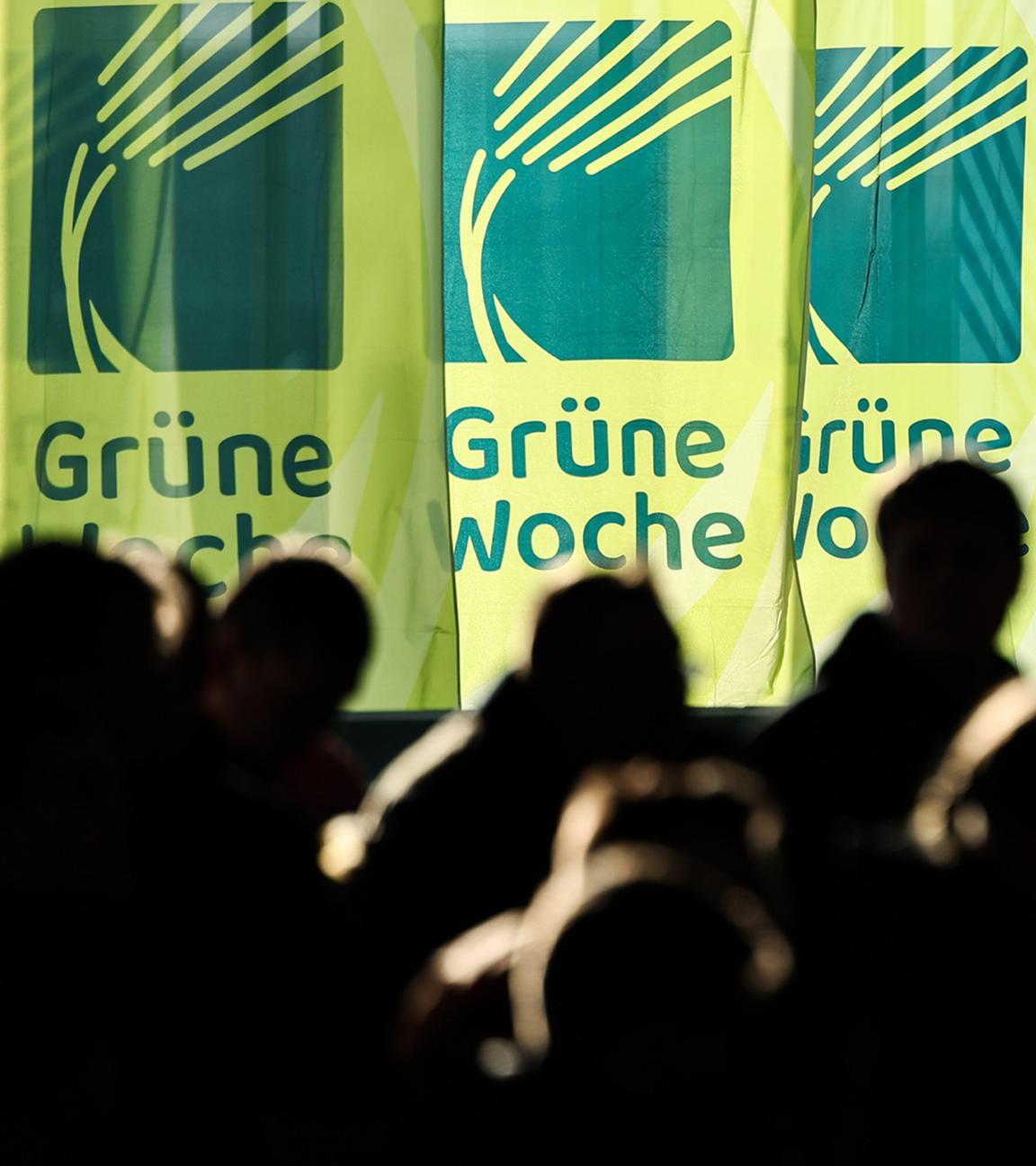 Besucher in einer Halle vor Flaggen der Grünen Woche. (Archiv)