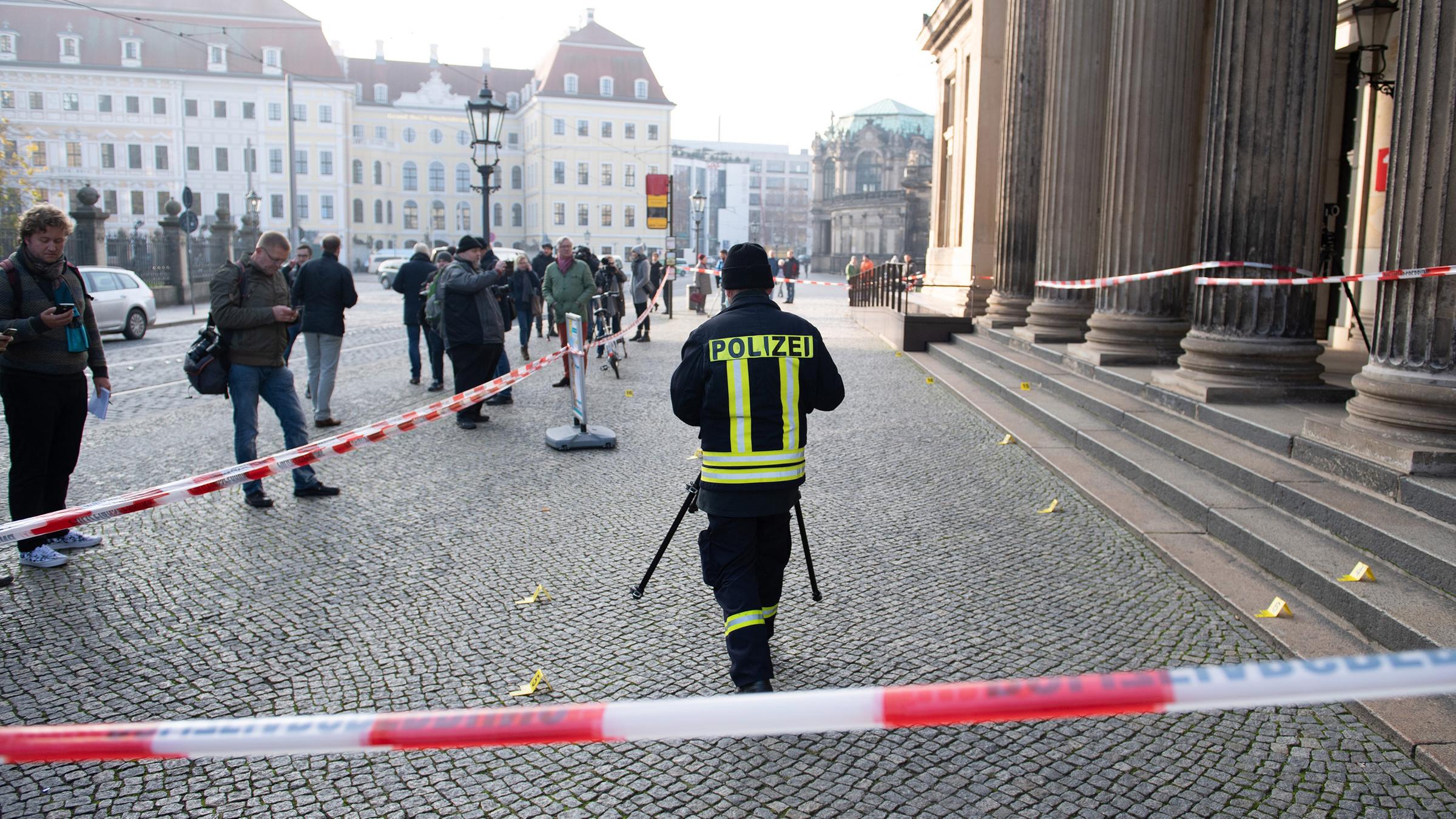 Ein Polizist steht vor dem Gebäude der Schinkelwache hinter einem Absperrband