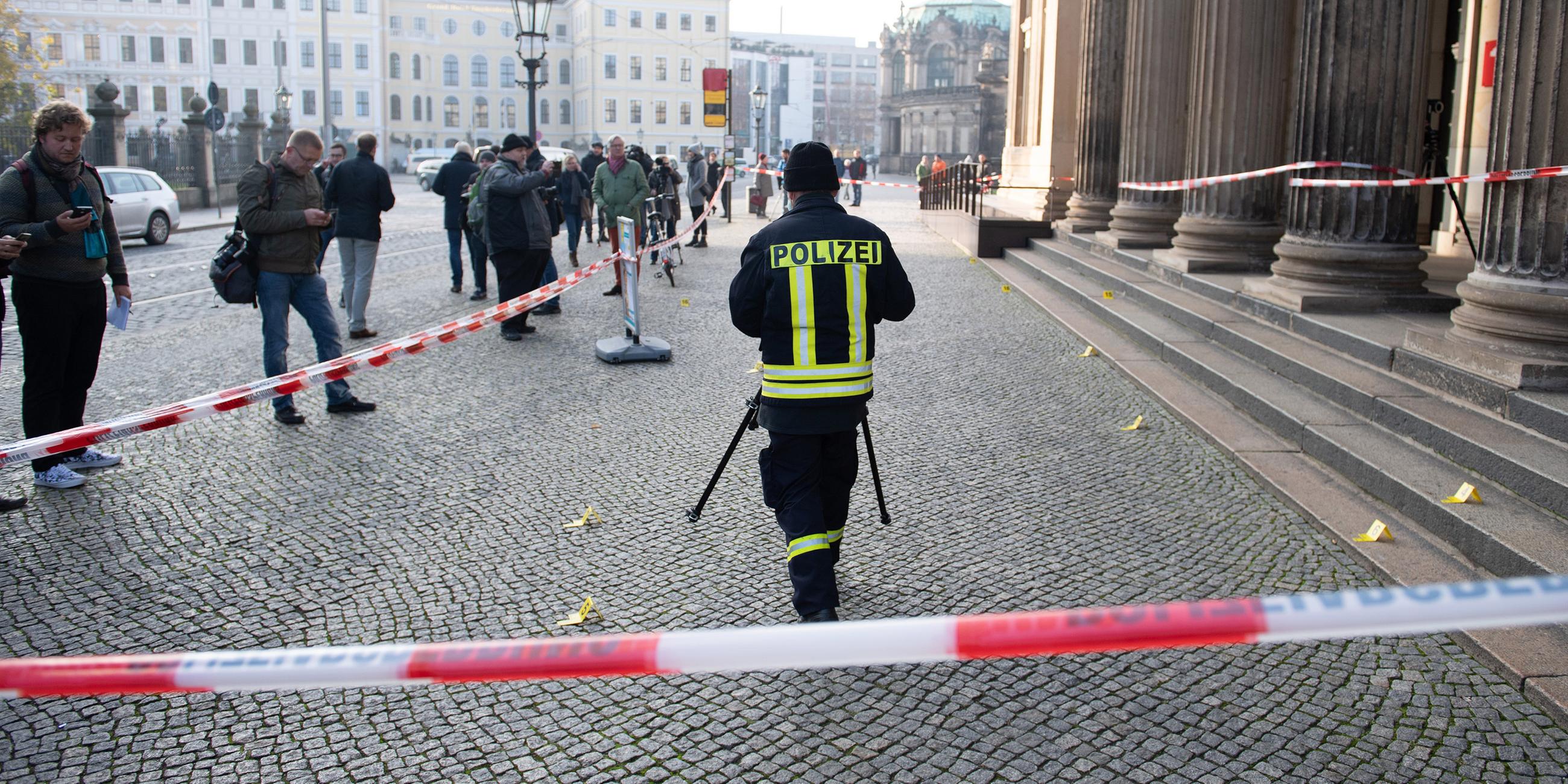 Ein Polizist steht vor dem Gebäude der Schinkelwache hinter einem Absperrband