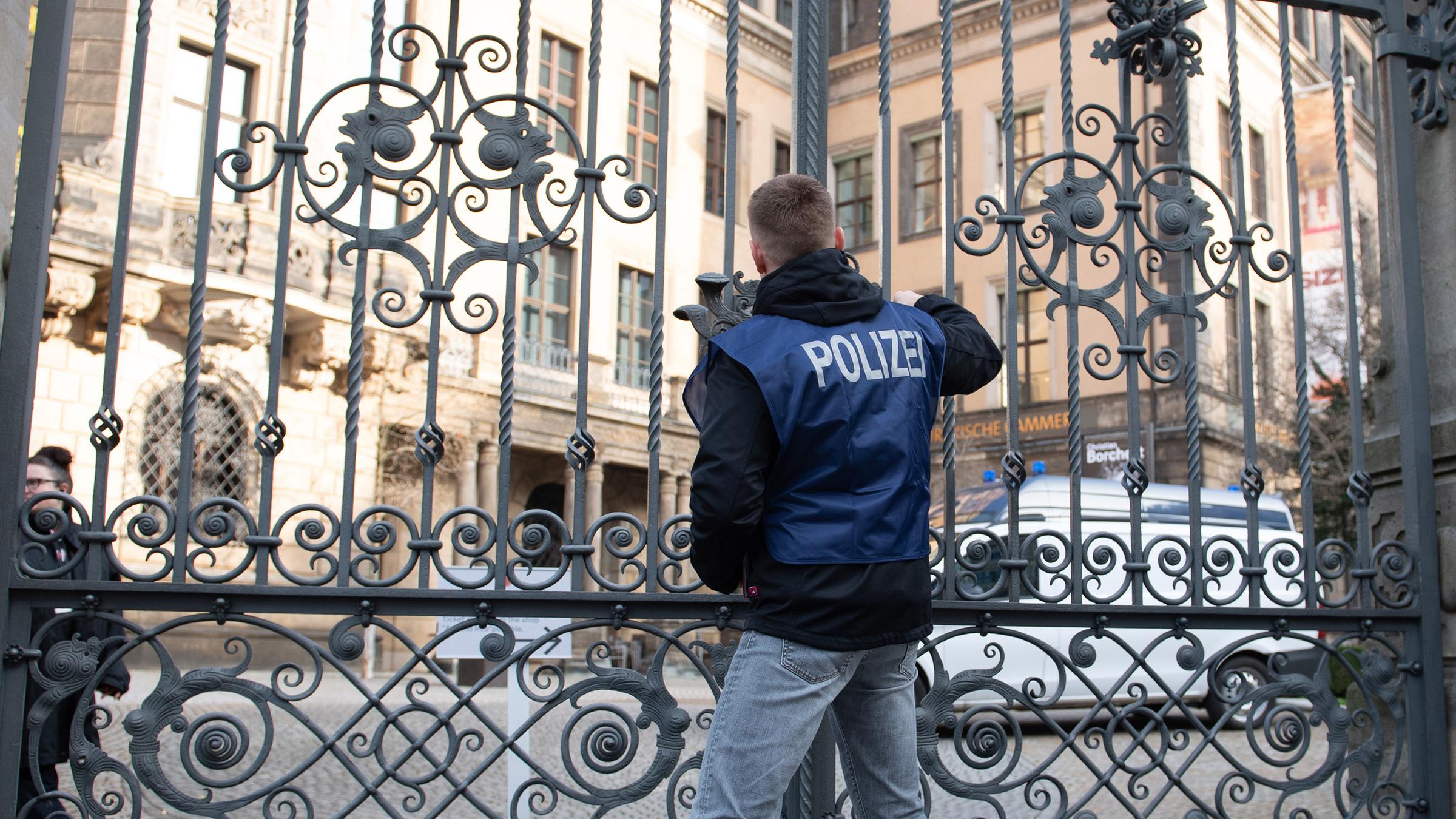 Ein Polizist verschließt vor dem Residenzschloss ein Tor