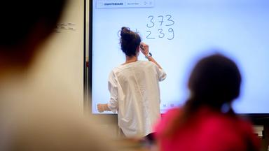 Ein Lehrerin schreibt eine Mathematikaufgabe auf eine digitale Schultafel im Klassenraum einer 4. Klasse einer Grundschule in der Region Hannover (Archivfoto)