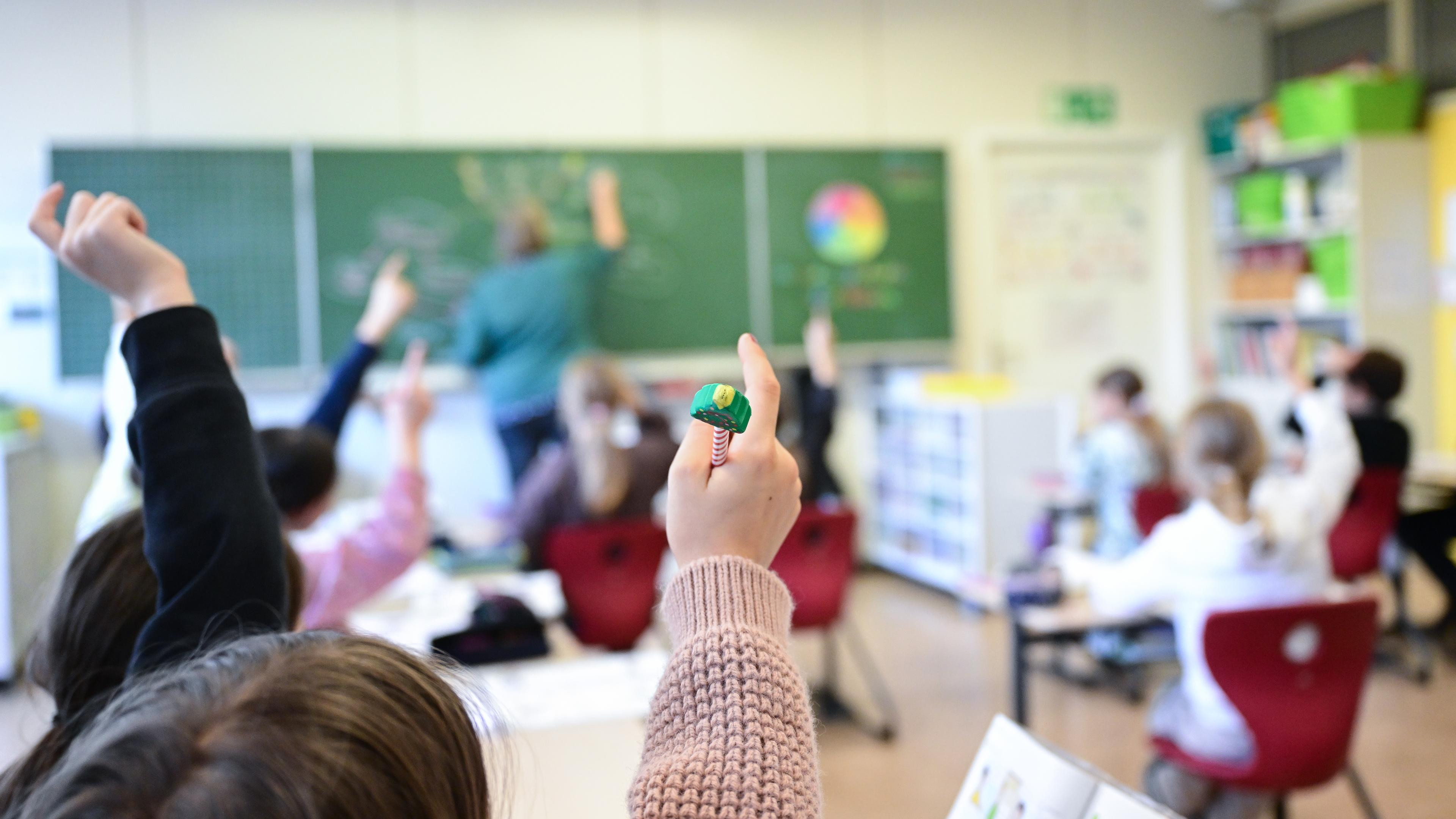 Schülerinnen und Schüler melden sich während des Untterichts in einer Grundschule