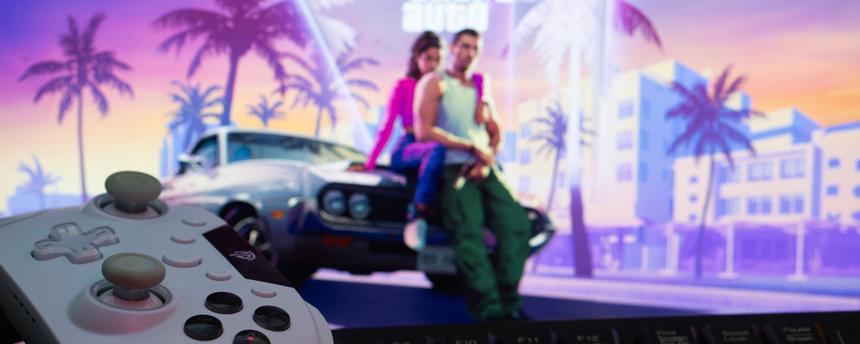 Eine Spielkonsole mit Gamepad und Tastatur vor einem Grand Theft Auto VI-Hintergrund auf einem Computermonitor. 