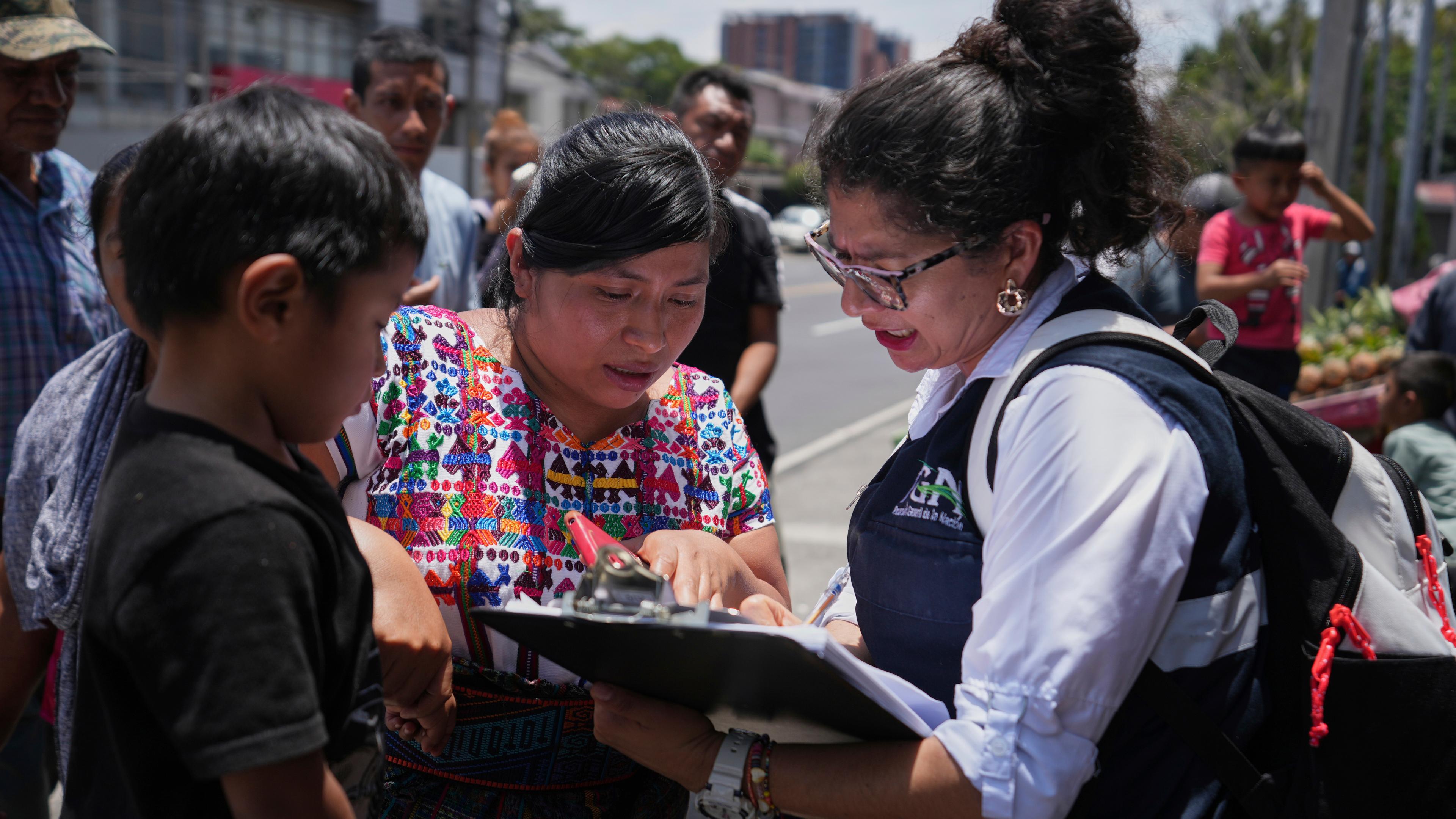 Eine Familienangehörige überprüft eine Namensliste von aus den USA abgeschobenen Migranten am Flughafen La Aurora in Guatemala Stadt.