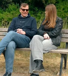 Guido Karbautzki und seine Tochter Emilia sitzen auf einer bank im Grünen
