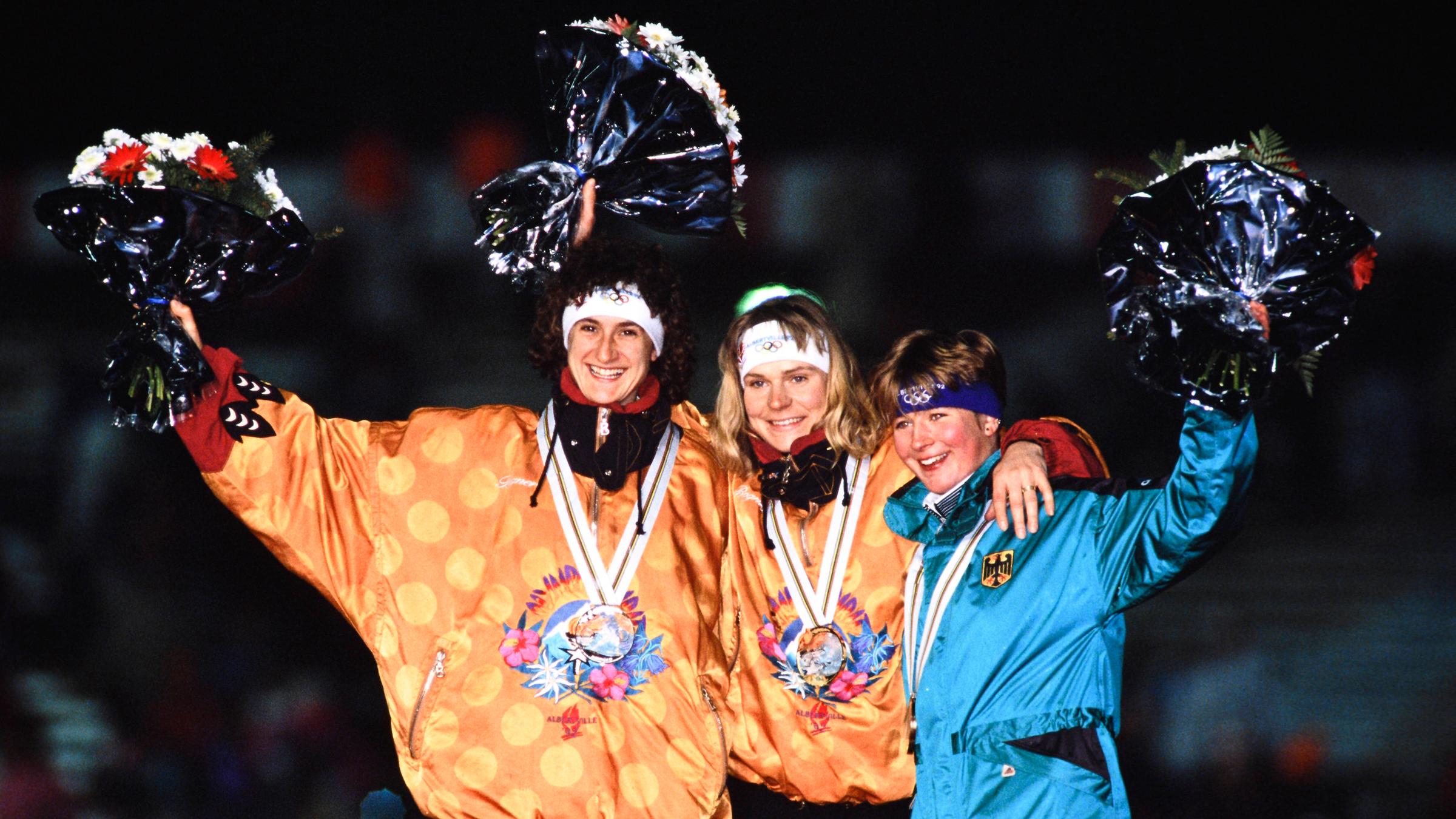 Die deutschen Eisschnelläuferinnen Heike Warnicke, Gunda Niemann und Claudia Pechstein (von links) jubeln bei der Siegerehrung bei den Olympischen Winterspielen 1992 in Albertville 