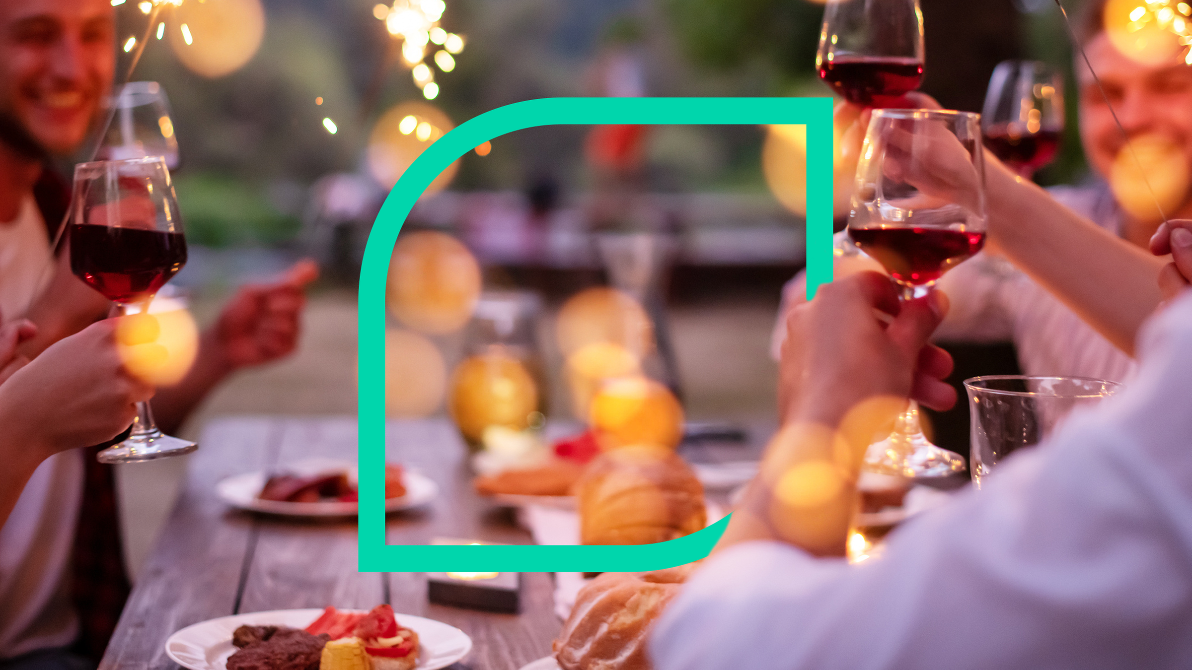 Menschen prosten sich an einem Tisch mit Weingläsern zu