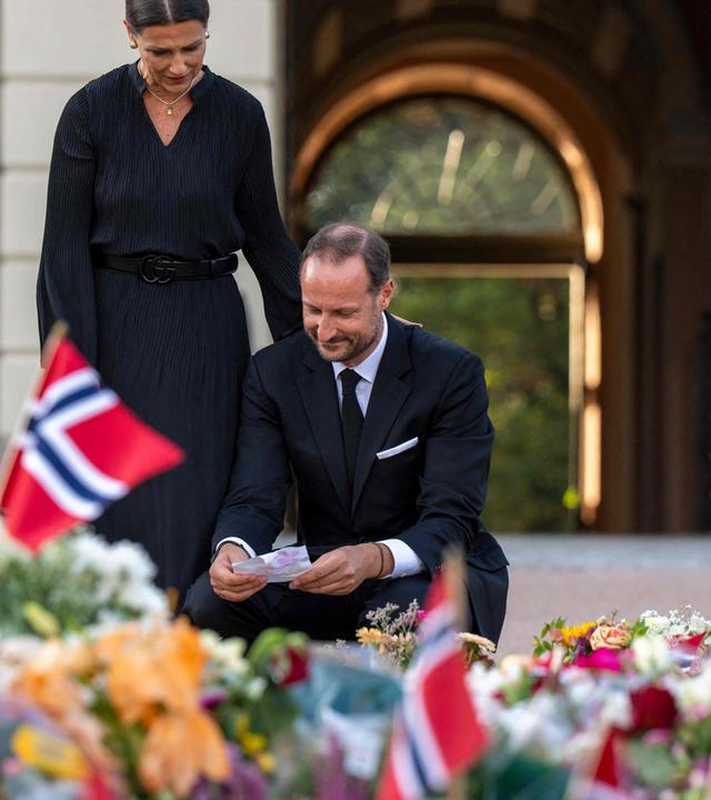 Auf dem Bild zu sehen ist: Haakon umgeben voll Trauer-Blumen.