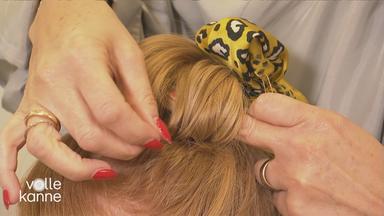 Frau stylt anderer Frau eine Knoten-Frisur