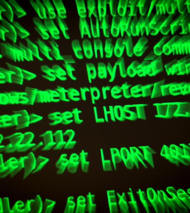 Buchstaben und Zahlen leuchten auf einem Bildschirm, auf dem ein Hacker-Programm geöffnet ist.