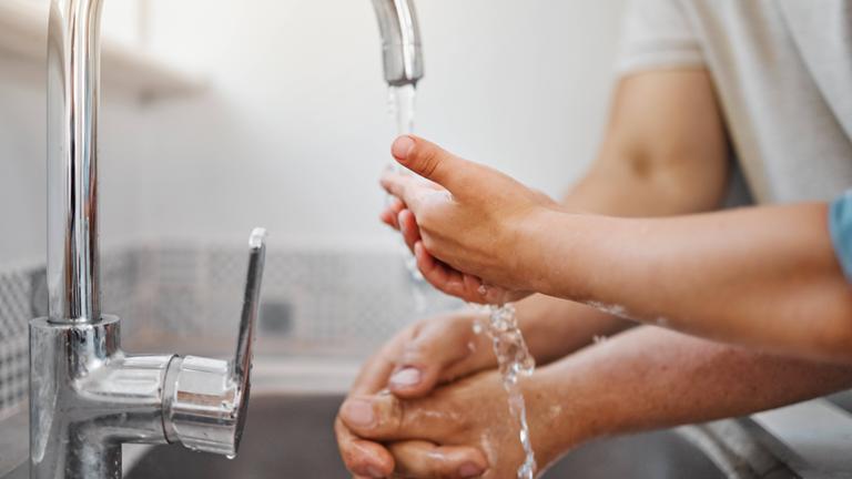 Ein Mann und ein Kind waschen sich gemeinsam die Hände.