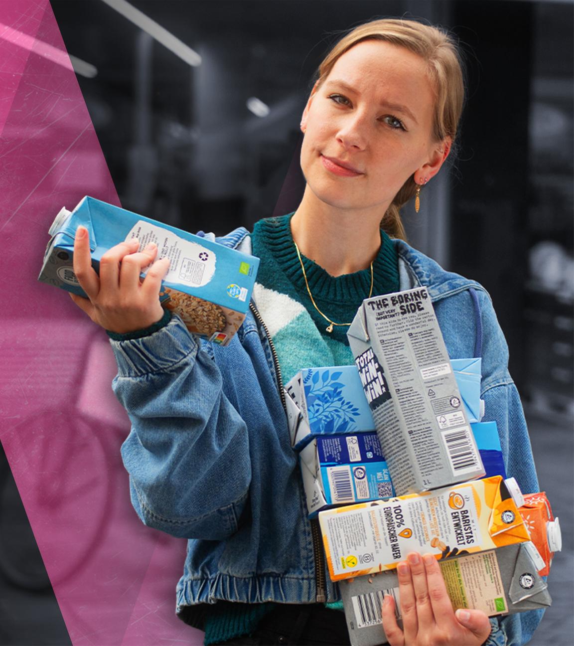 Sabrina Zimmermann hält verschiedene Verpackungen von Haferdrink in der Hand