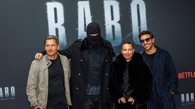 Auf dem Bild ist der Rapper Haftbefehl, seine Ehefrau und die Regiesseure seiner Dokumentation zu sehen. Sie alle posieren auf dem Roten Teppich der Premiere.