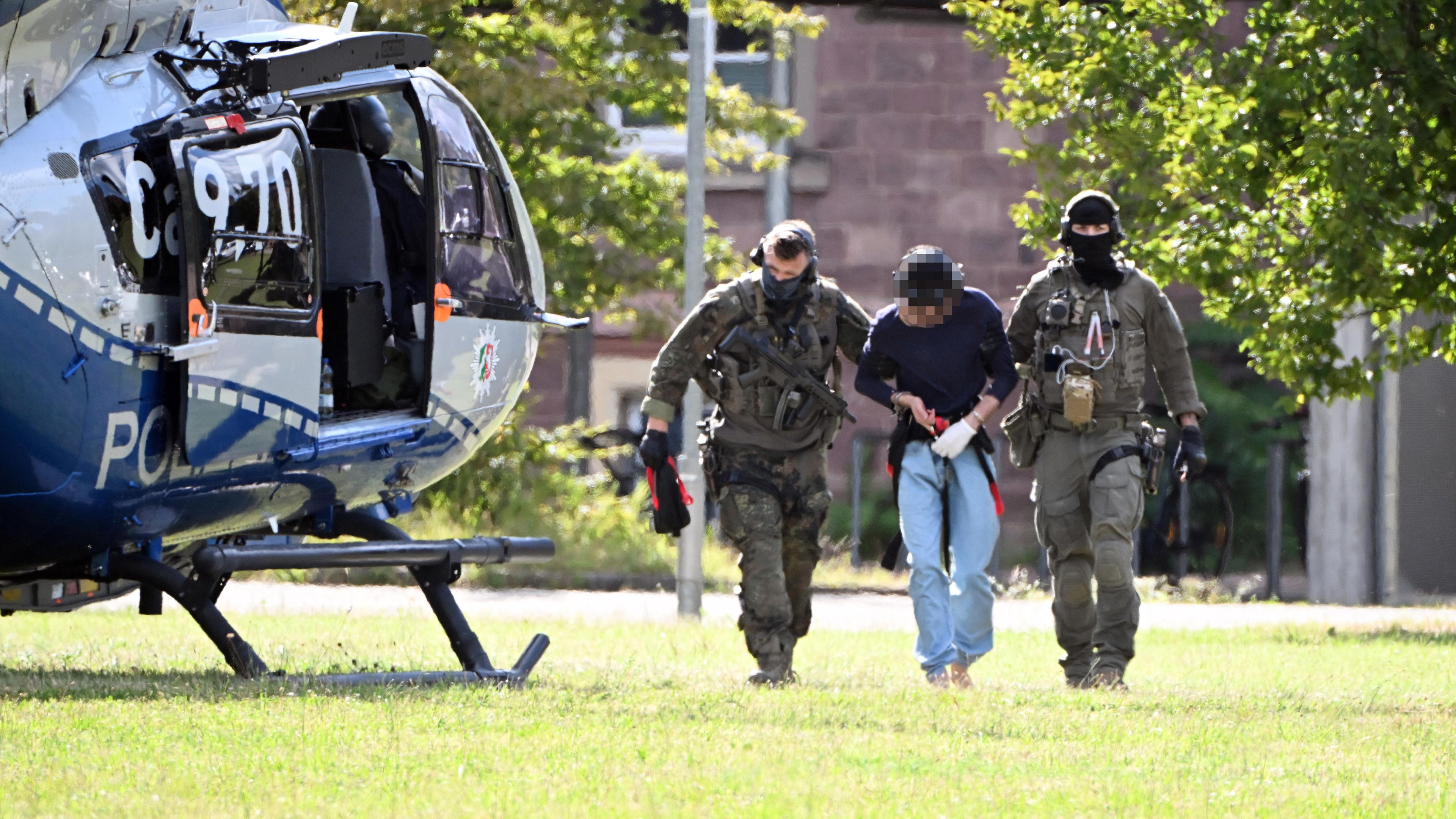 Baden-Württemberg, Karlsruhe: Der mutmassliche Täter des Messerangriffs von Solingen wird zu einem Hubschrauber gebracht.