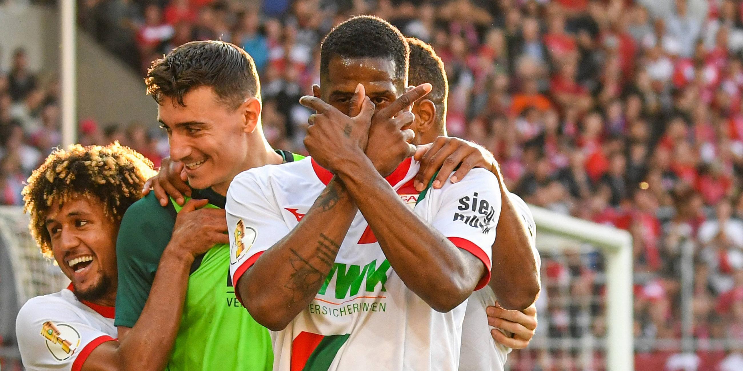 DFB-Pokal: Halle gegen Augsburg. Samuel Essende vom FC Augsburg kreuzt die Finger vor dem Gesicht beim Torjubel.