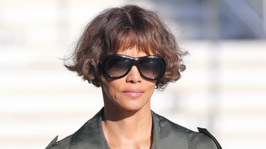 Die amerikanische Schauspielerin und Regisseurin Halle Berry trägt eine große schwarze Sonnenbrille und schaut in die Kamera.