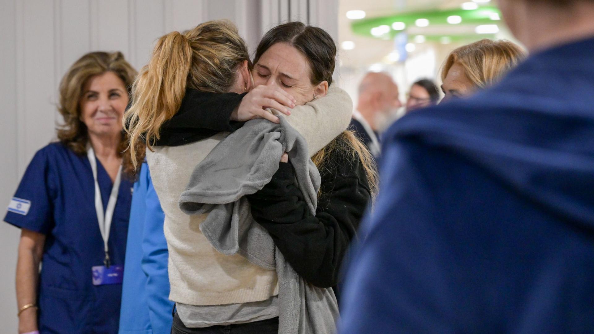 Eine freigelassene Geisel aus den Händen der Hamas, die ihre Familie umarmt.